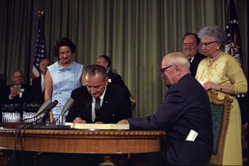 Lyndon B. Johnson signing the Medicare bill. 